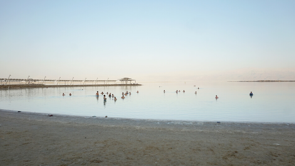 morze martwe plaża zohar beach kąpiący się ludzie zachód słońca