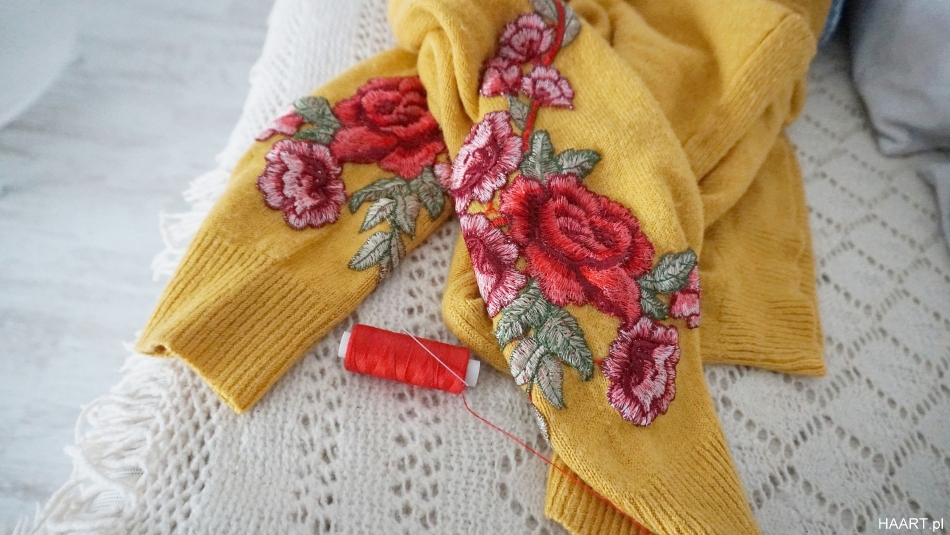 Sweter z kwiatami na rękawach